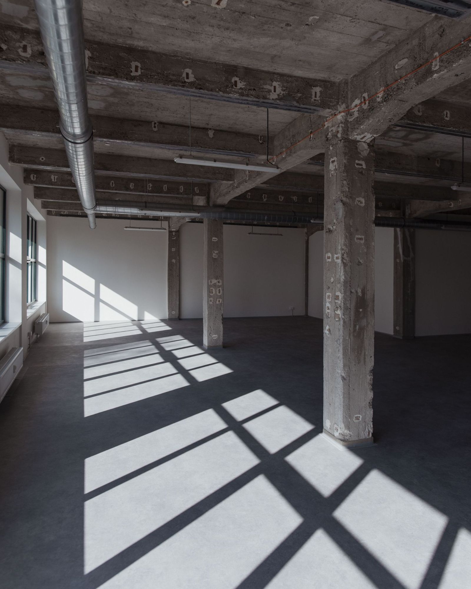 Studio s velkými okny a stíny rámů na podlaze